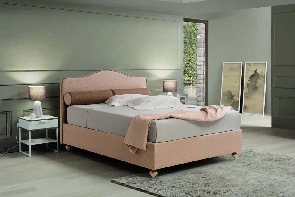 Una camera da letto con un letto rosa e due comodini