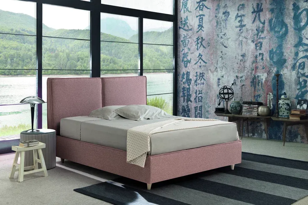 Una camera da letto con un letto rosa e una scritta cinese sul muro