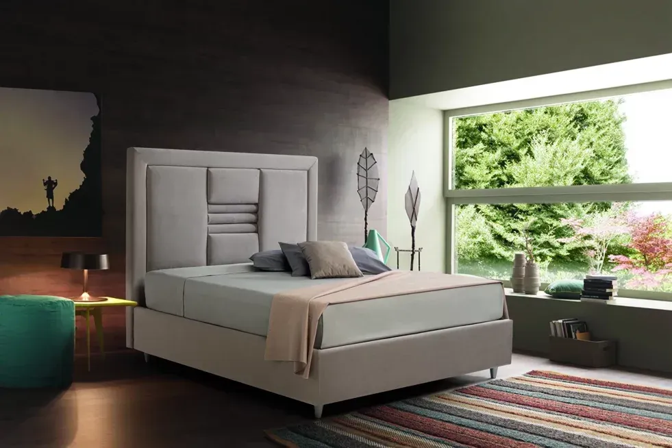 Un letto è posizionato in una camera da letto accanto a una finestra.