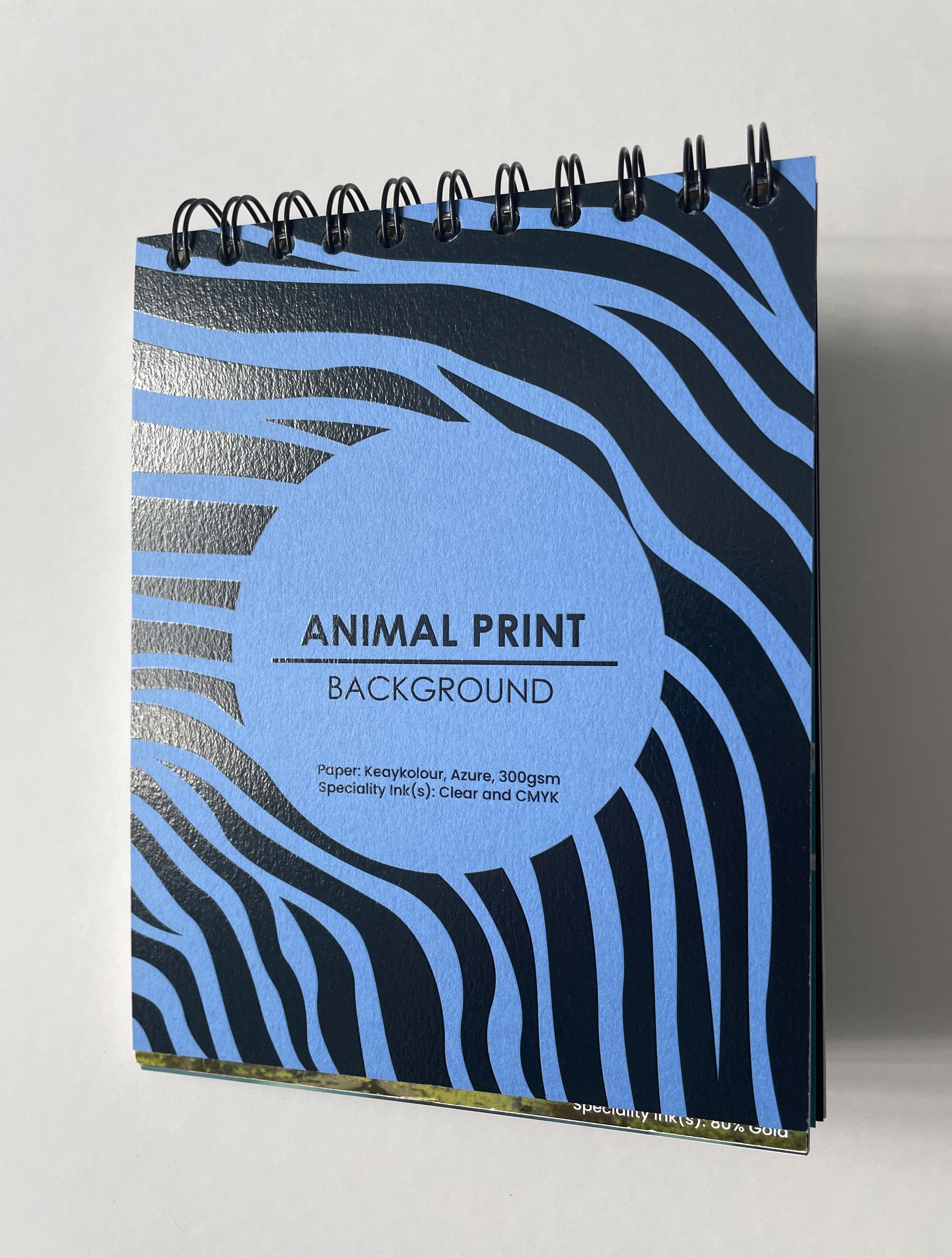 Blue zebra-striped notepad with black spiral binding, reads