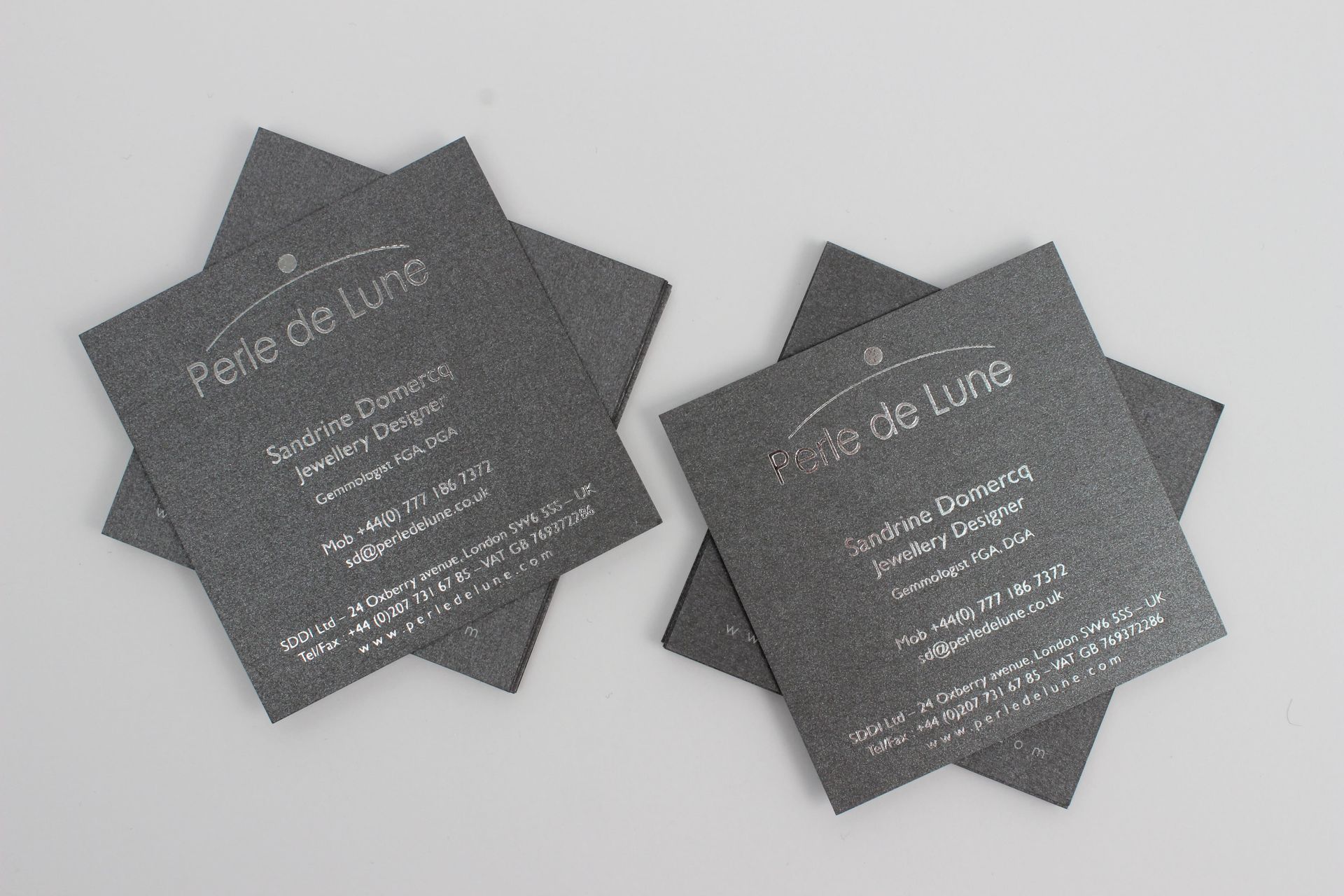 Gray business cards stacked, with white text: