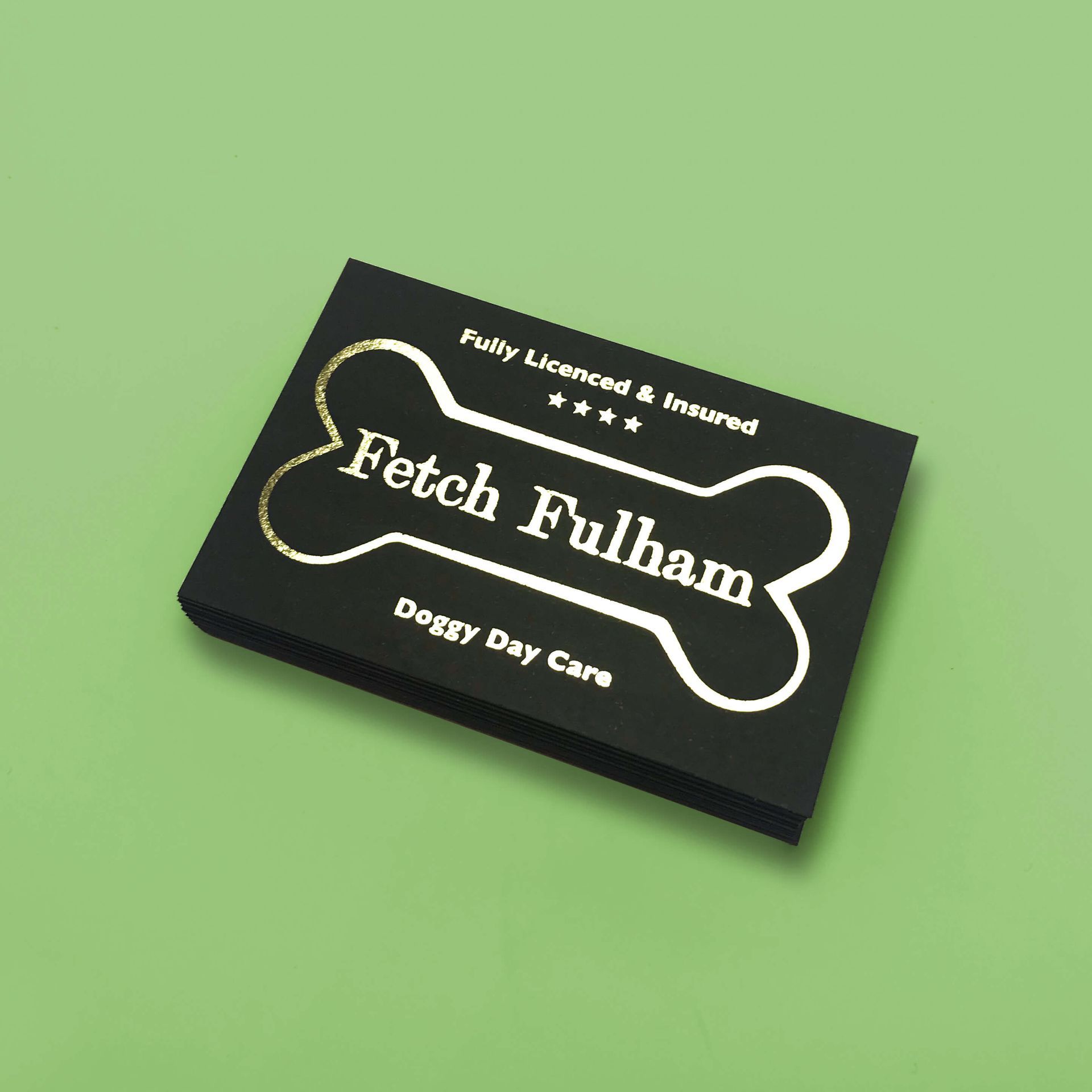 Black business card with gold bone logo for