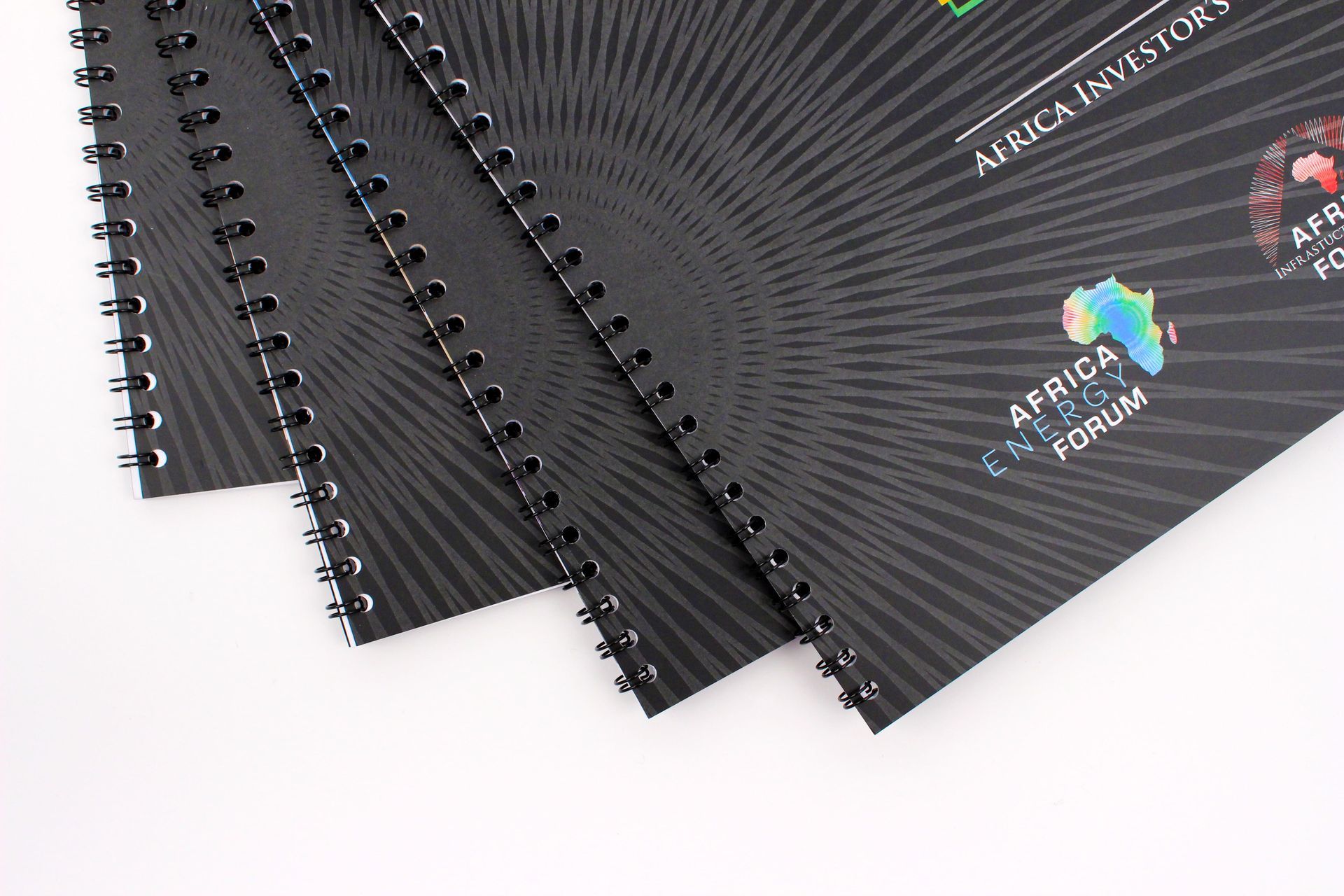 Black spiral-bound documents fanned out;