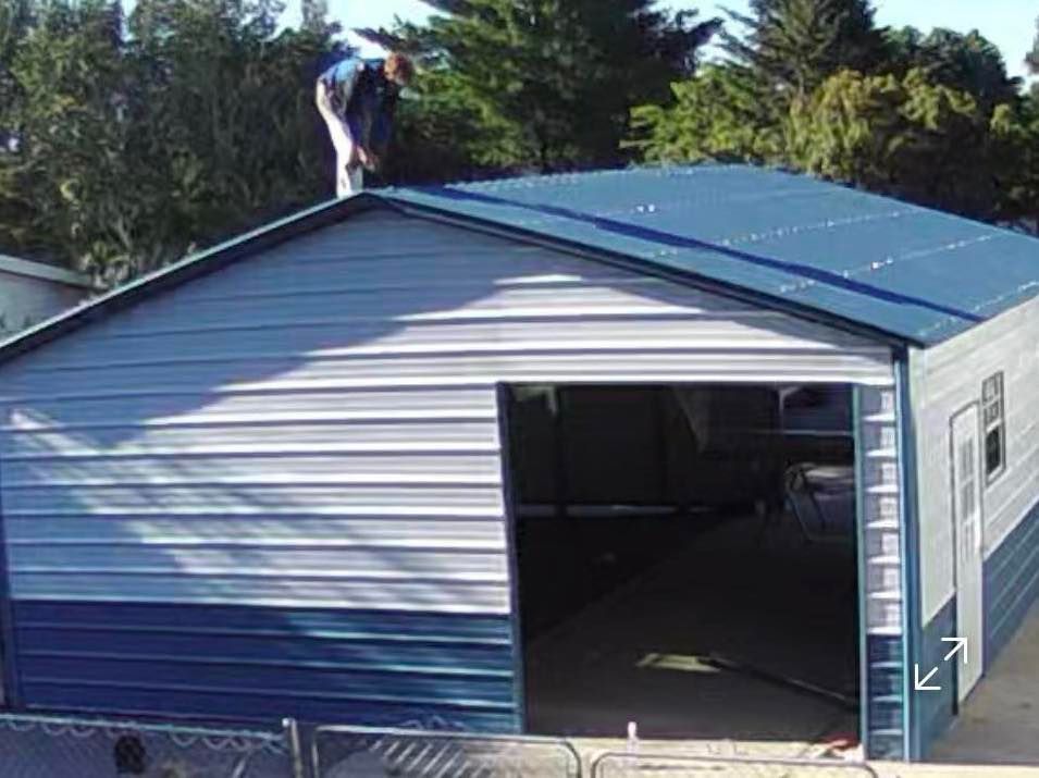 Person on a blue and gray metal garage roof; open doorway.