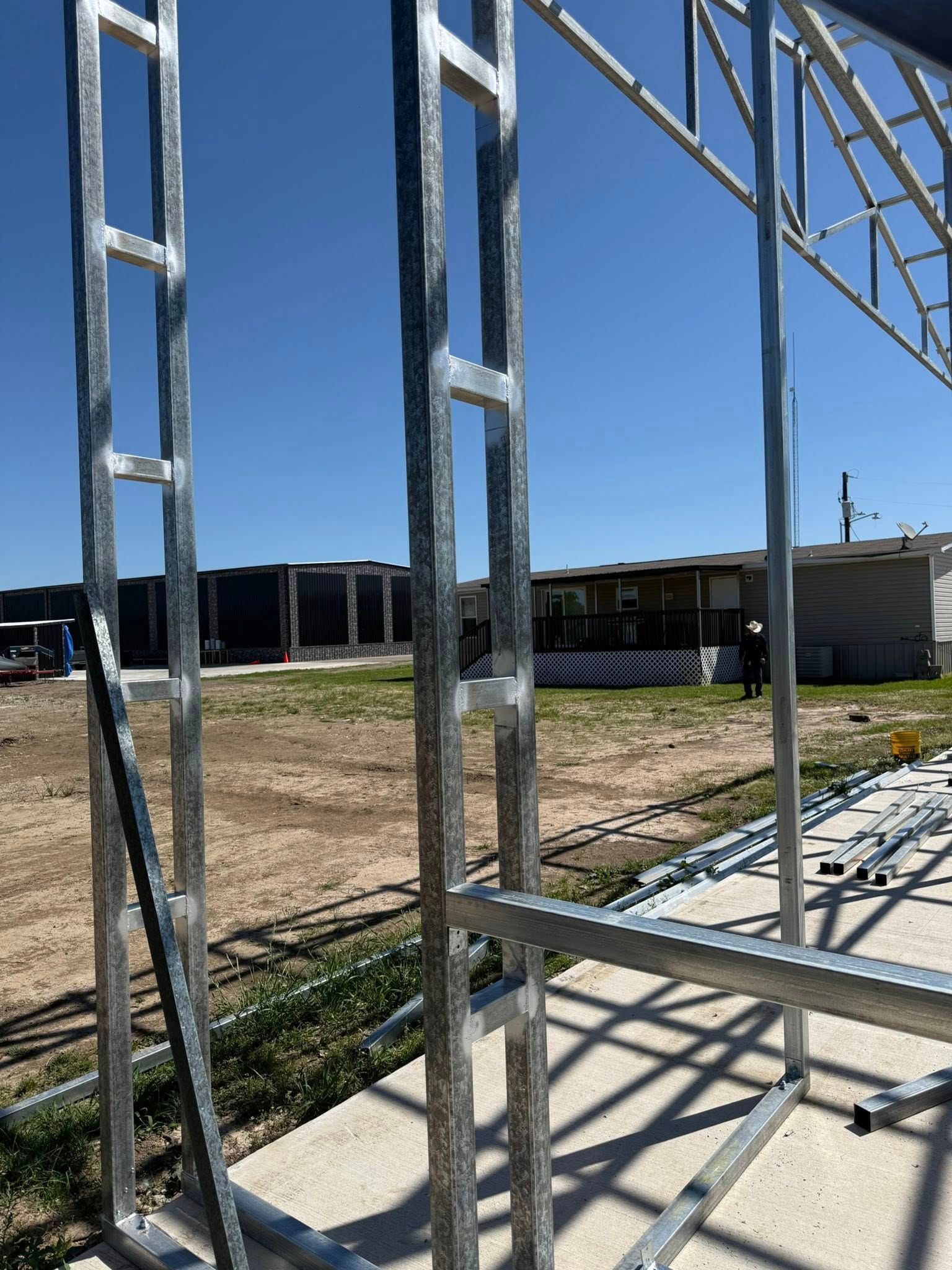 Metal framing of a structure under construction, outdoors on a sunny day.