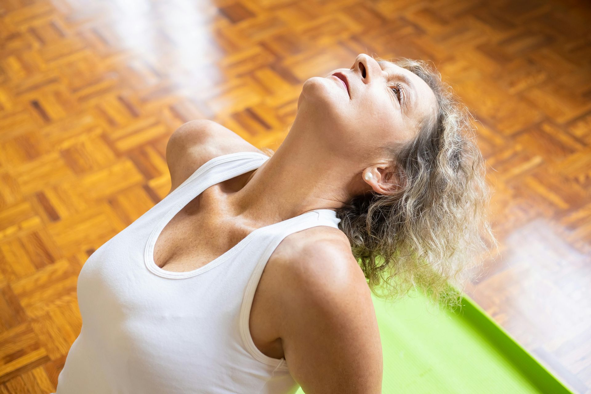 A man is helping a woman do exercises in a gym.