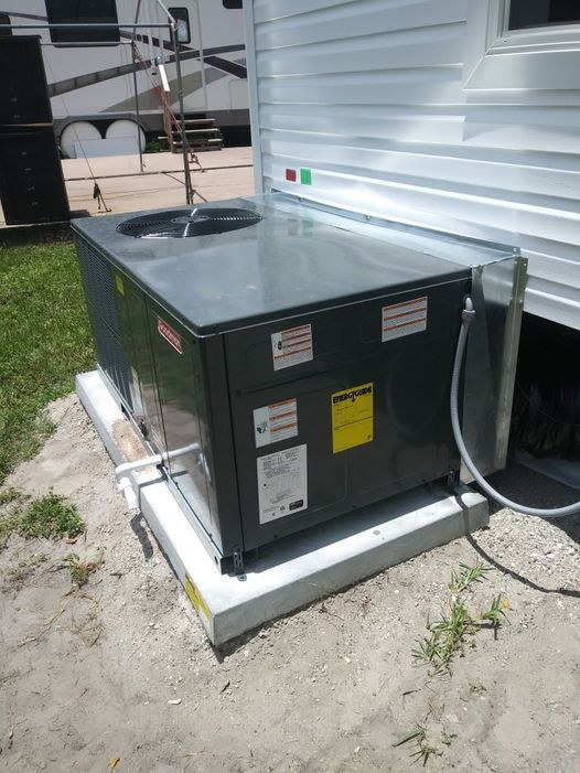 an air conditioner is sitting outside of a trailer .