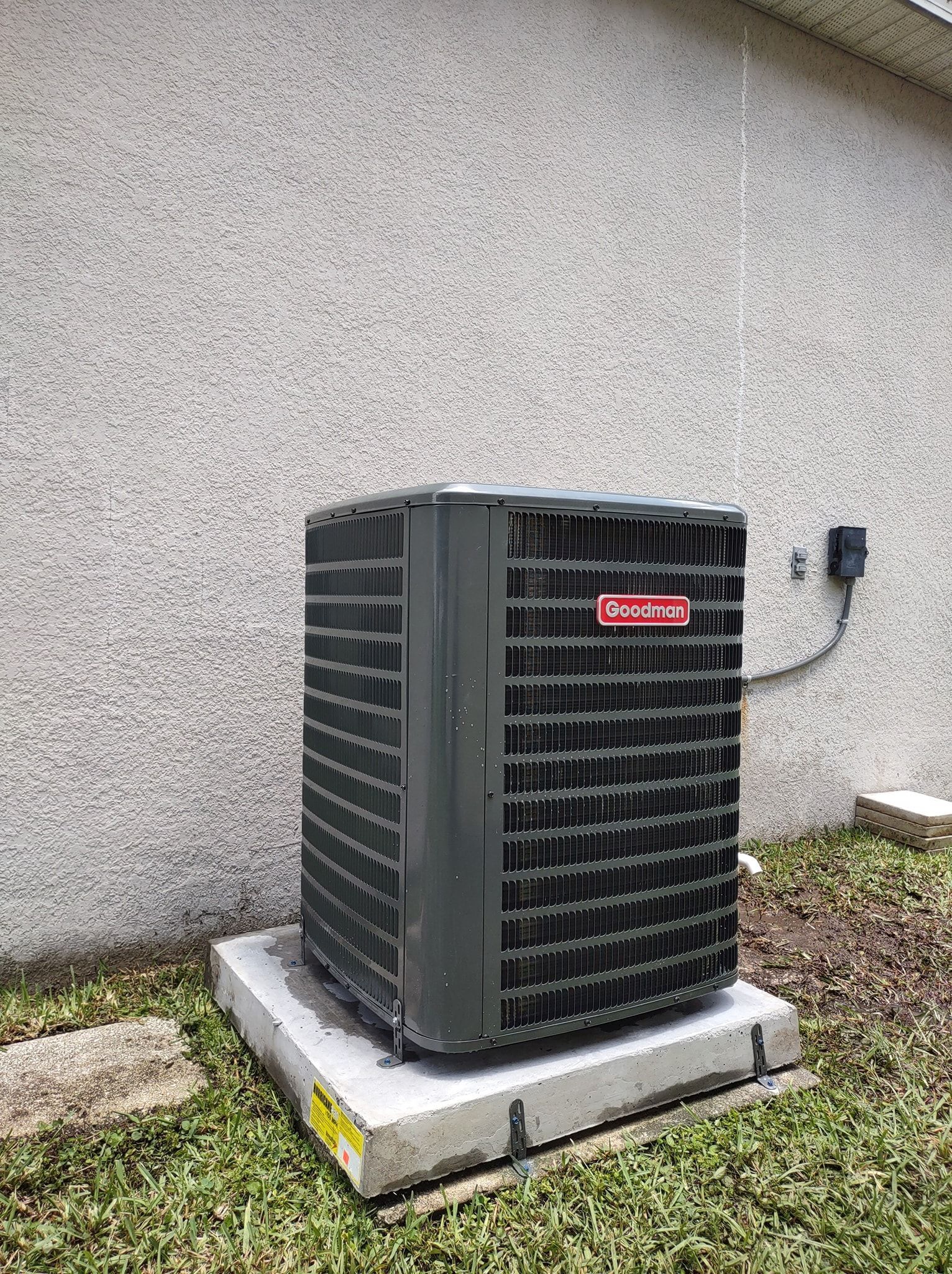 a large air conditioner is sitting on top of a concrete platform in front of a building .