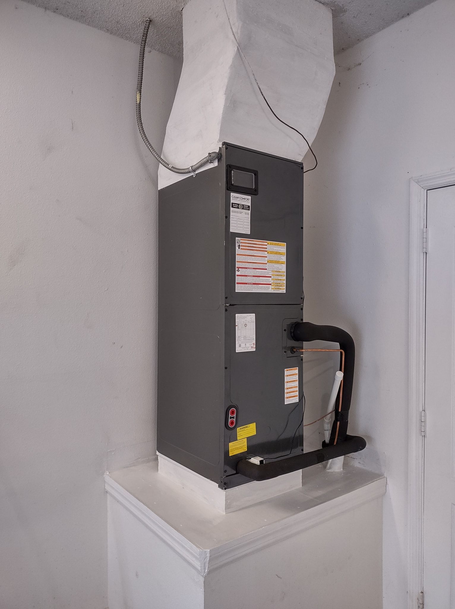 a black box is sitting on top of a white shelf in a room .