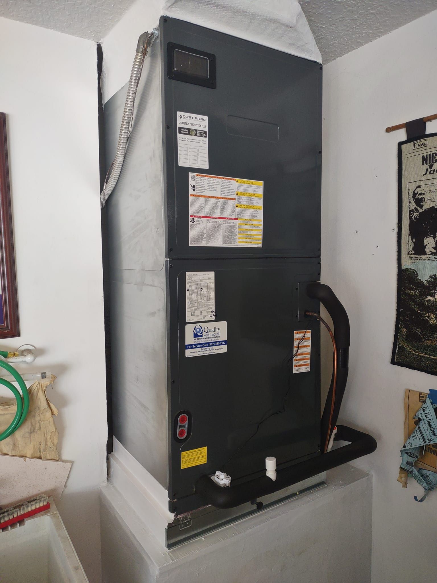 a black refrigerator is sitting in a room next to a wall .