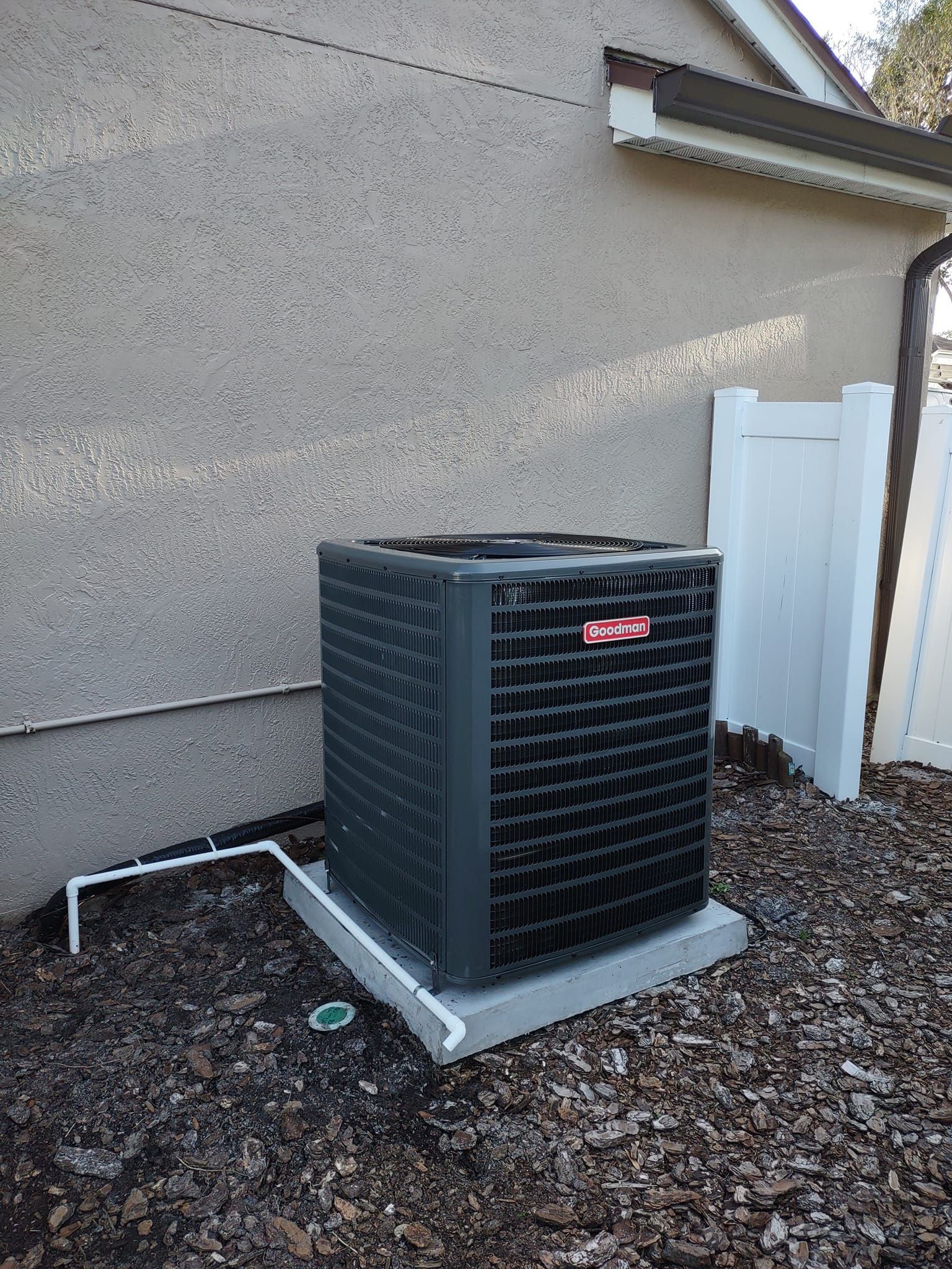 a large air conditioner is sitting outside of a house .