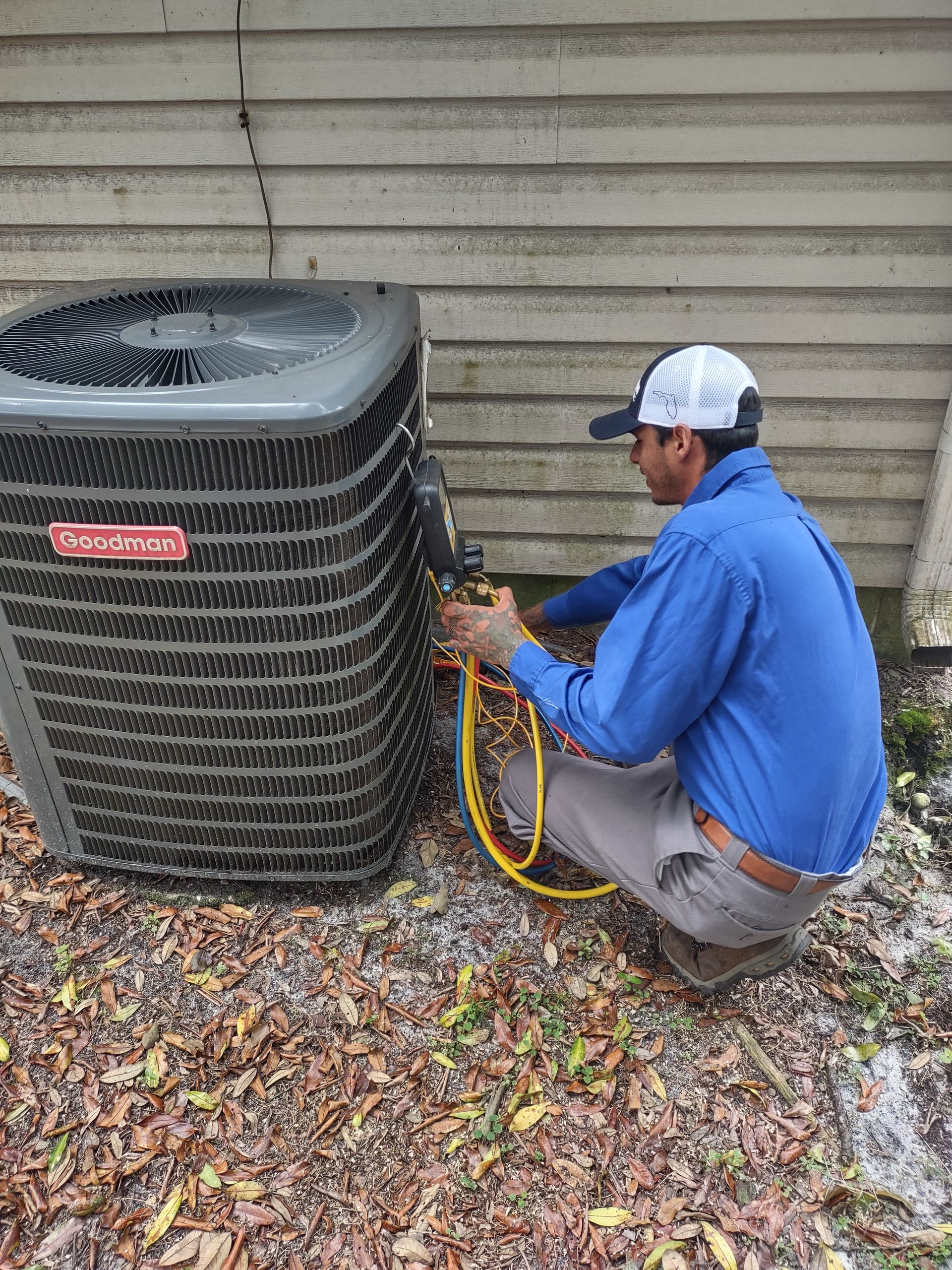 a man is working on an air conditioner outside of a house .