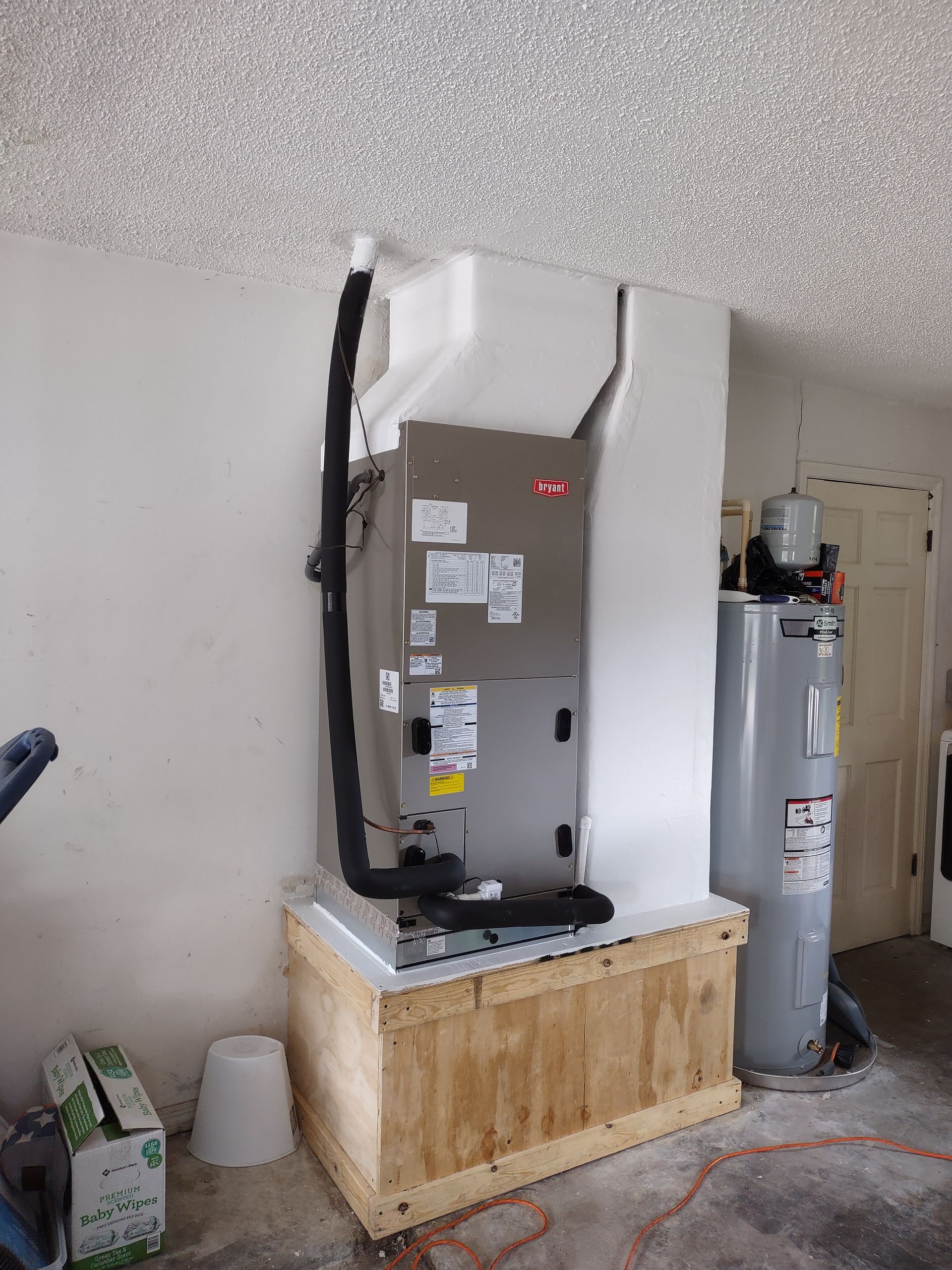 an air conditioner is sitting on top of a wooden box in a garage .