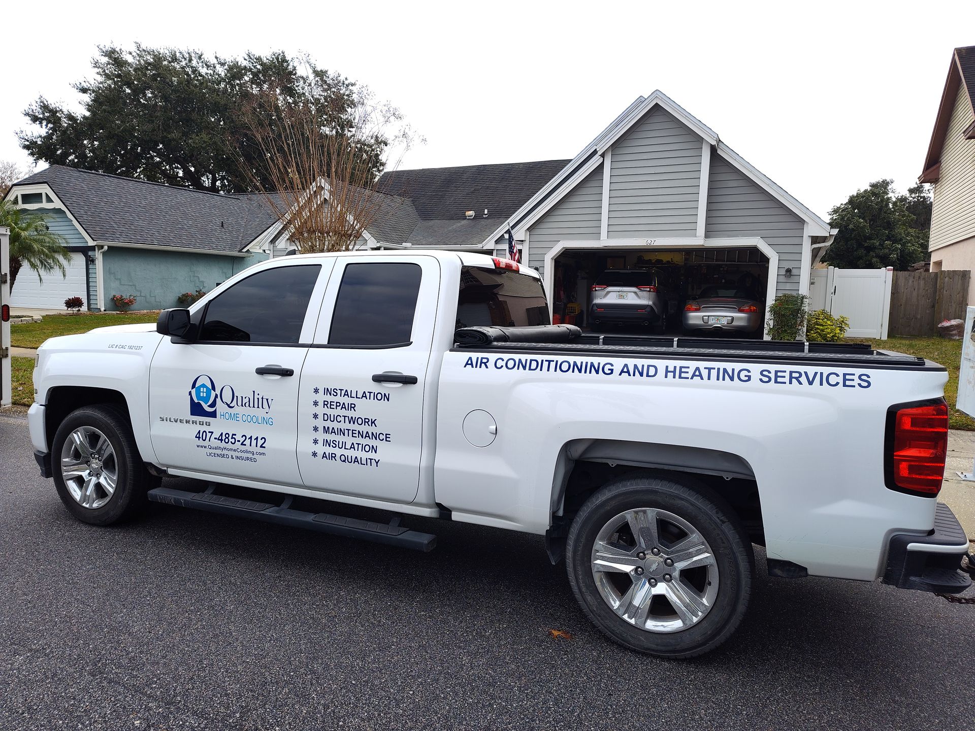 a white truck is parked in front of a house .