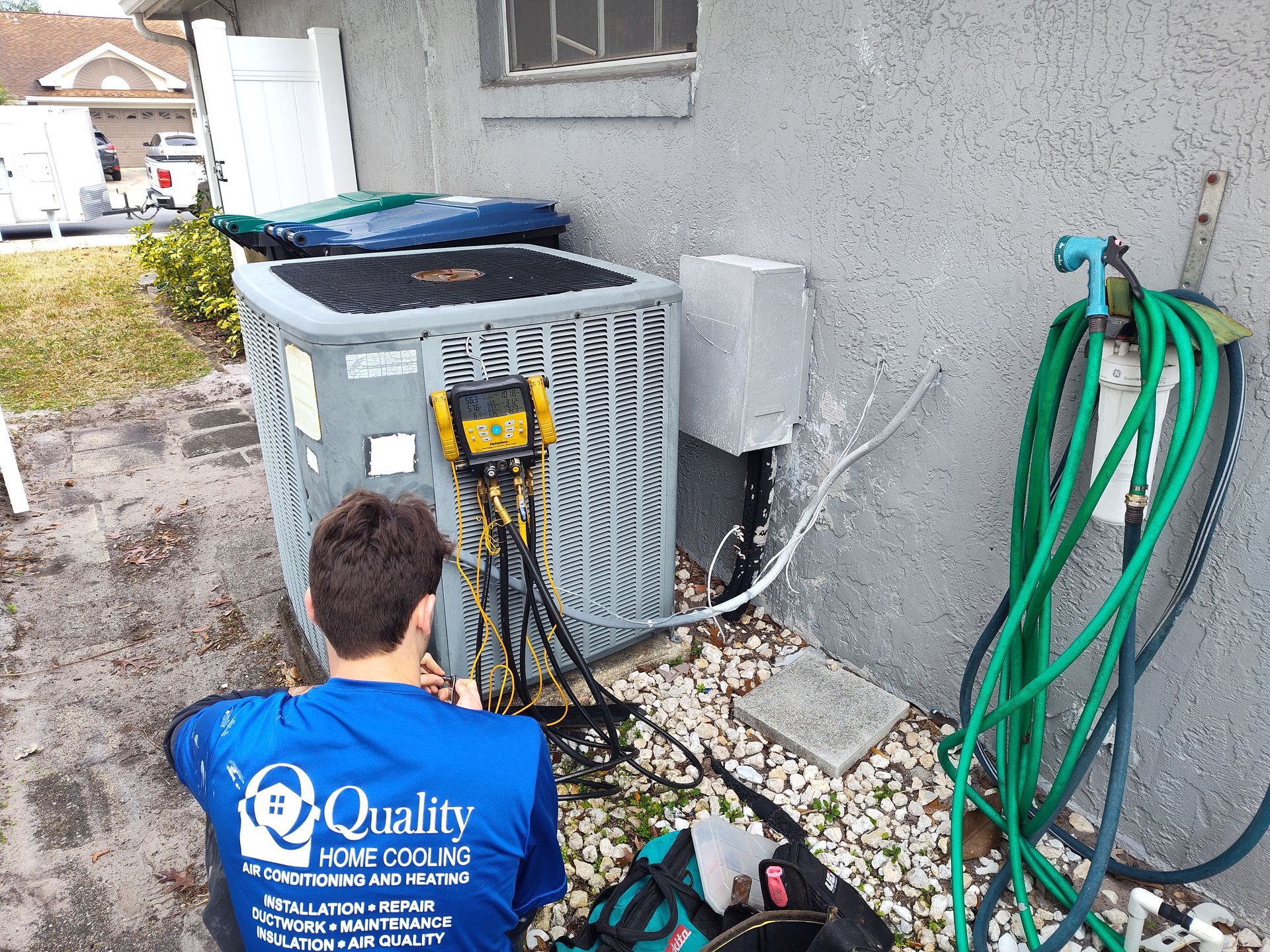 a man is working on an air conditioner outside of a house .