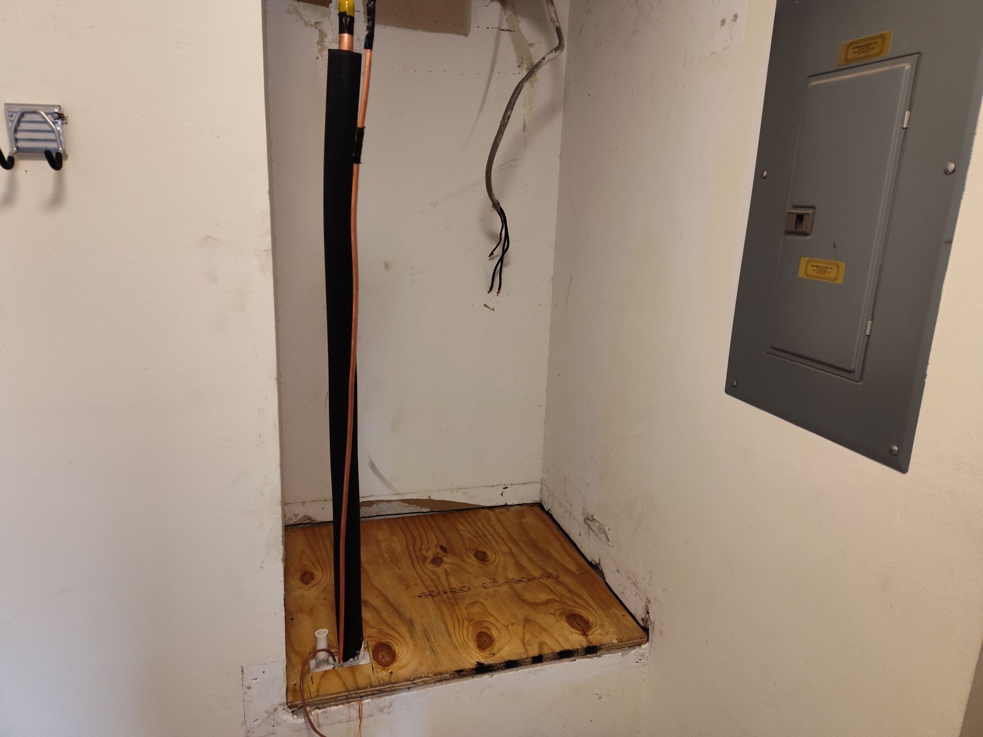 a room with a wooden floor and a electrical box on the wall .