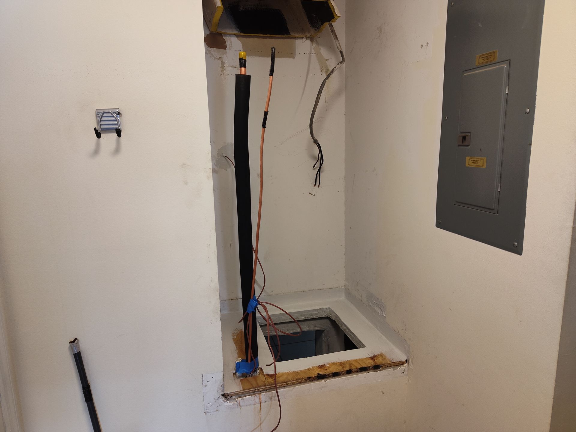 a hole in the floor of a room with a pipe coming out of it