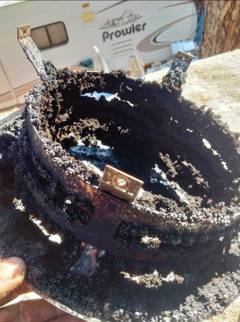 Chimney sweep cleaners showing creosote buildup on chimney cap during chimney inspection.