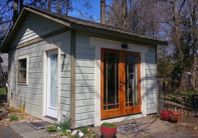 A Small House With a Wooden Door and Windows
