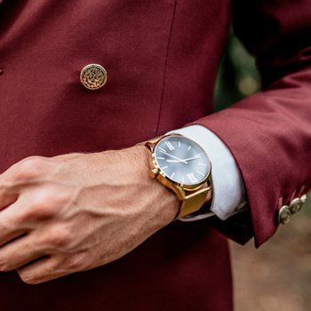 Closeup of man hands with golden watch buckling suit jacket