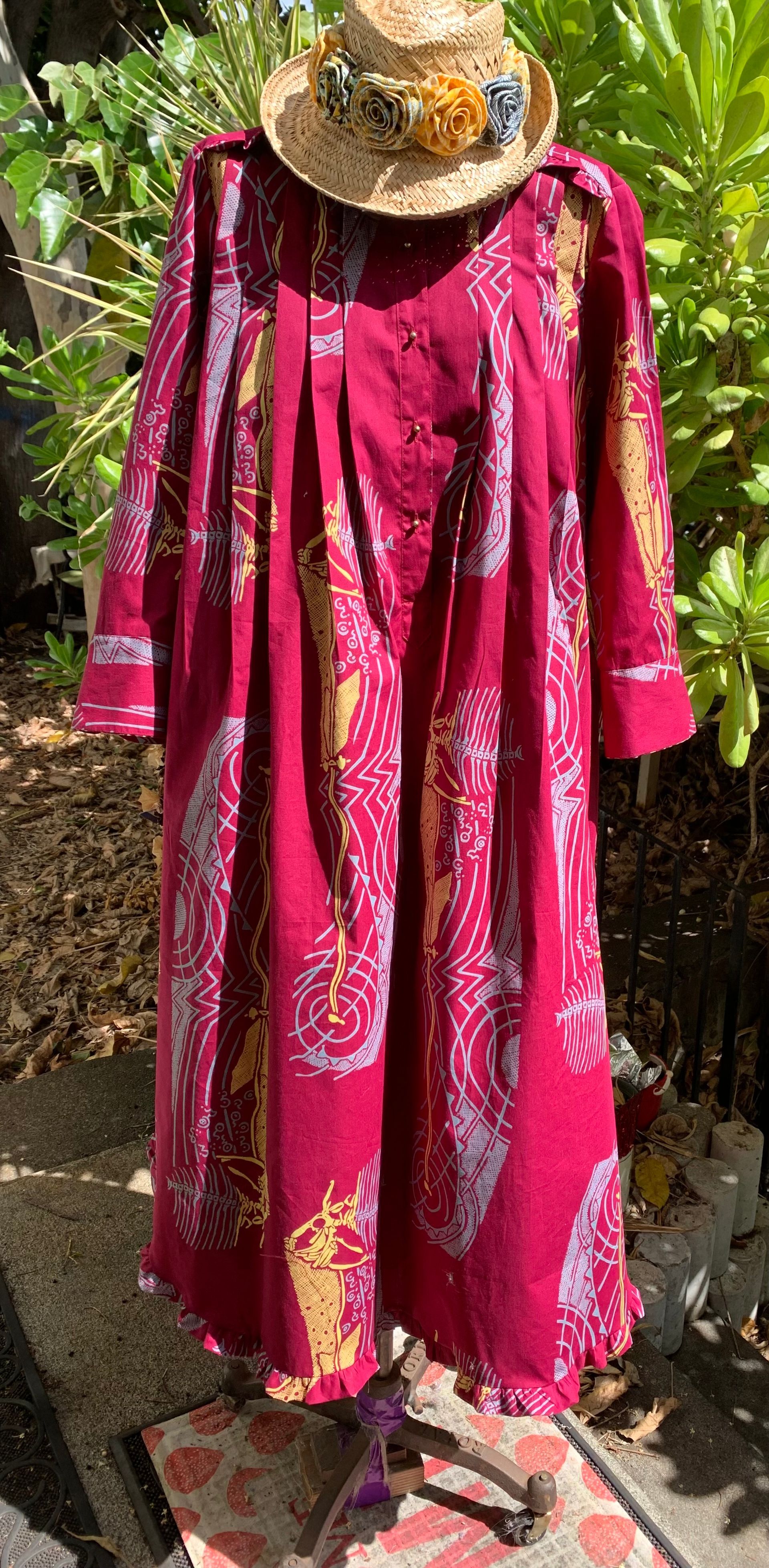 A mannequin wearing a red dress and a straw hat.