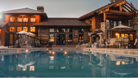 A large house with a swimming pool in front of it.