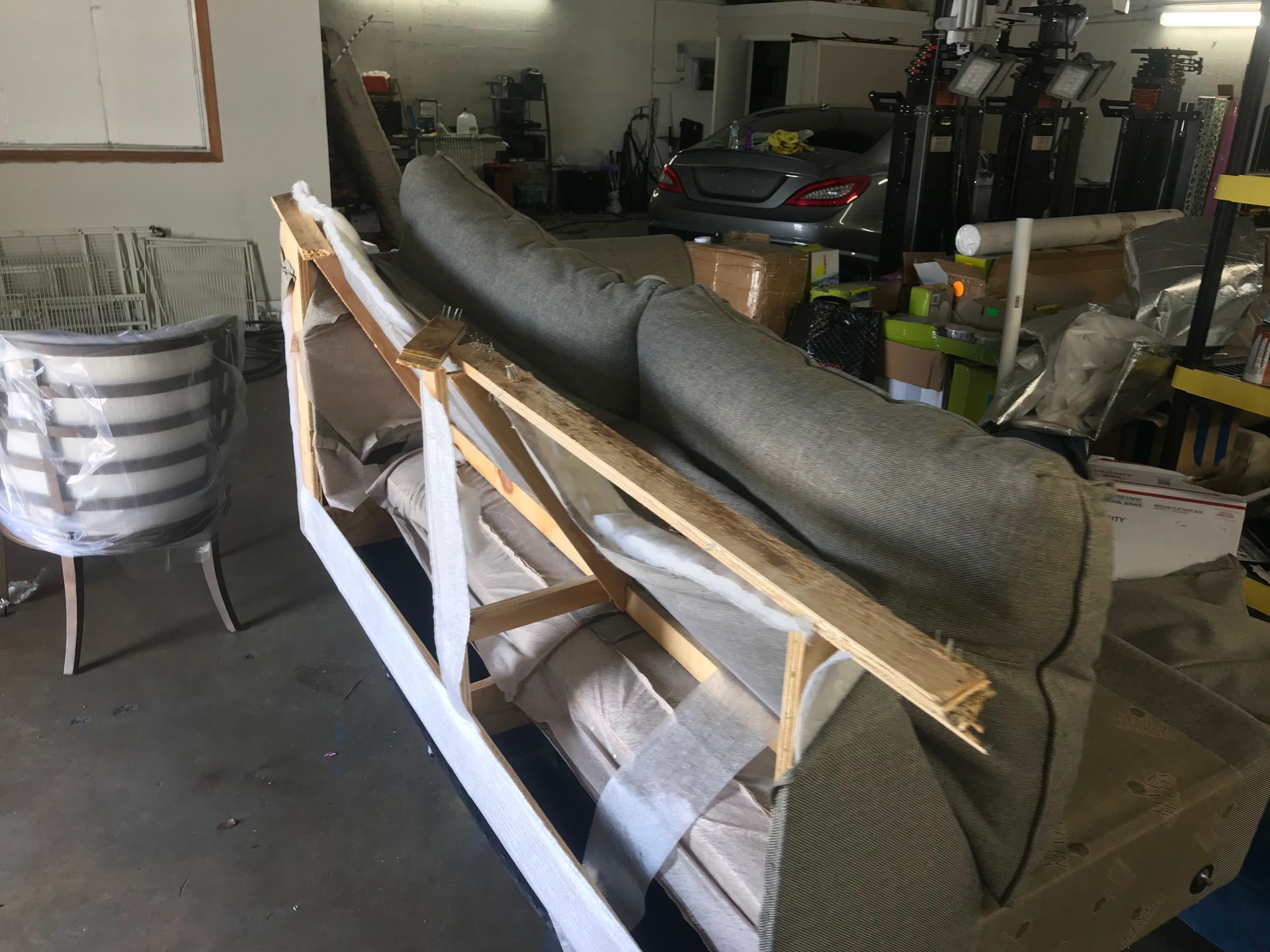 A couch is sitting in a wooden frame in a garage.