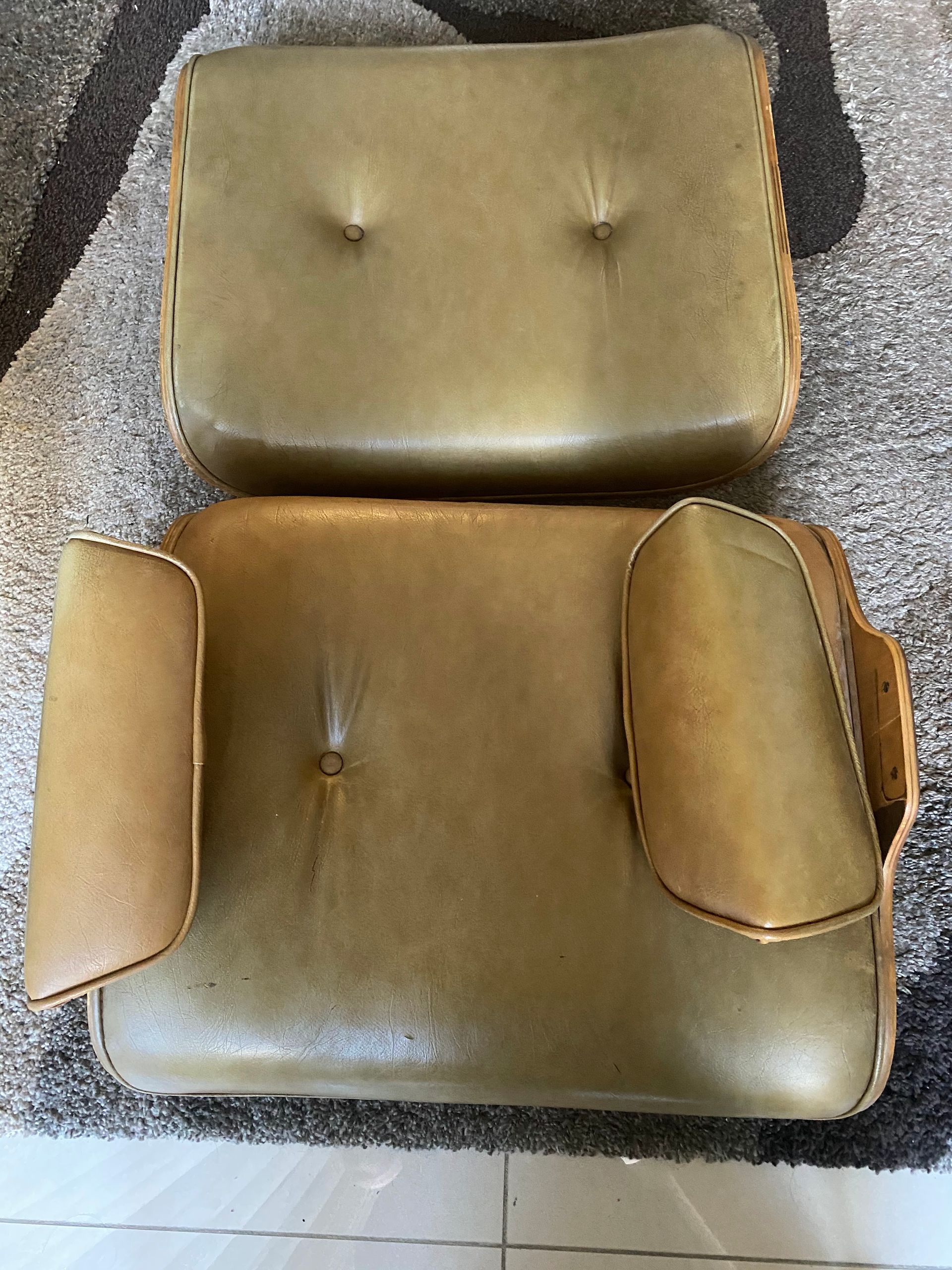 A brown leather chair and ottoman are sitting on a rug.