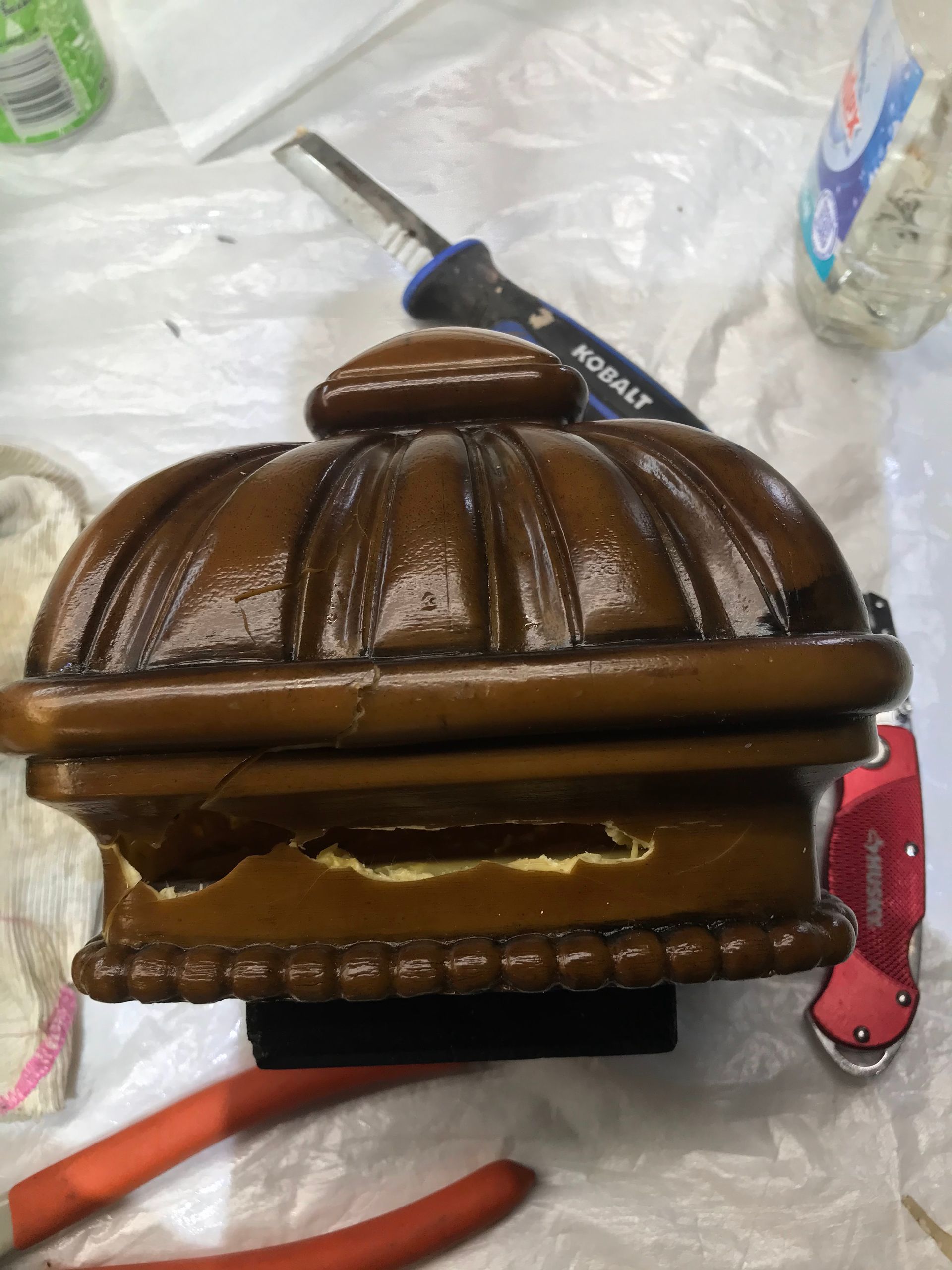 A wooden box is sitting on a table next to a pair of pliers and a screwdriver.