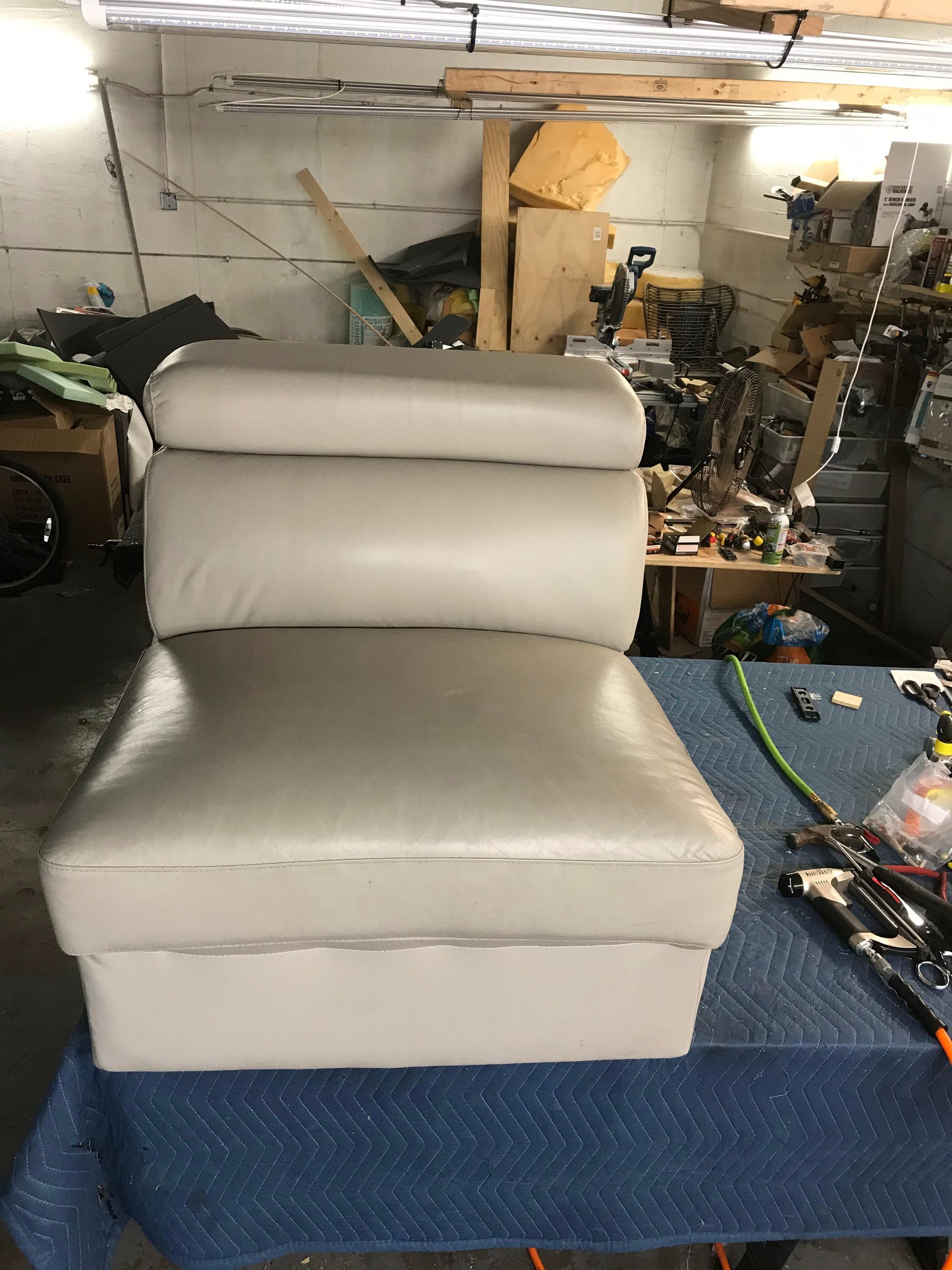 A chair is sitting on top of a table in a garage.