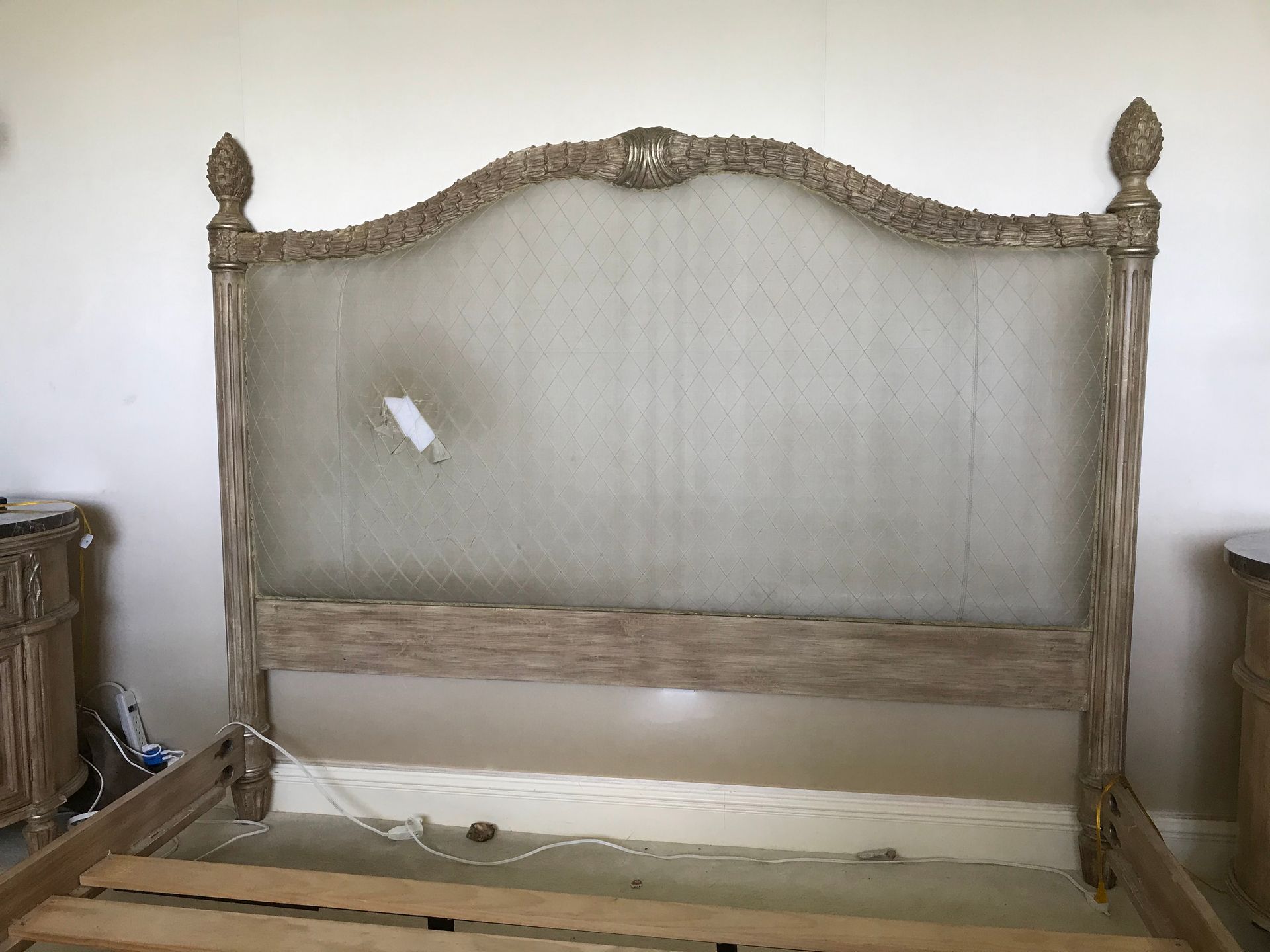 A bed with a wooden frame and a mesh headboard in a bedroom.