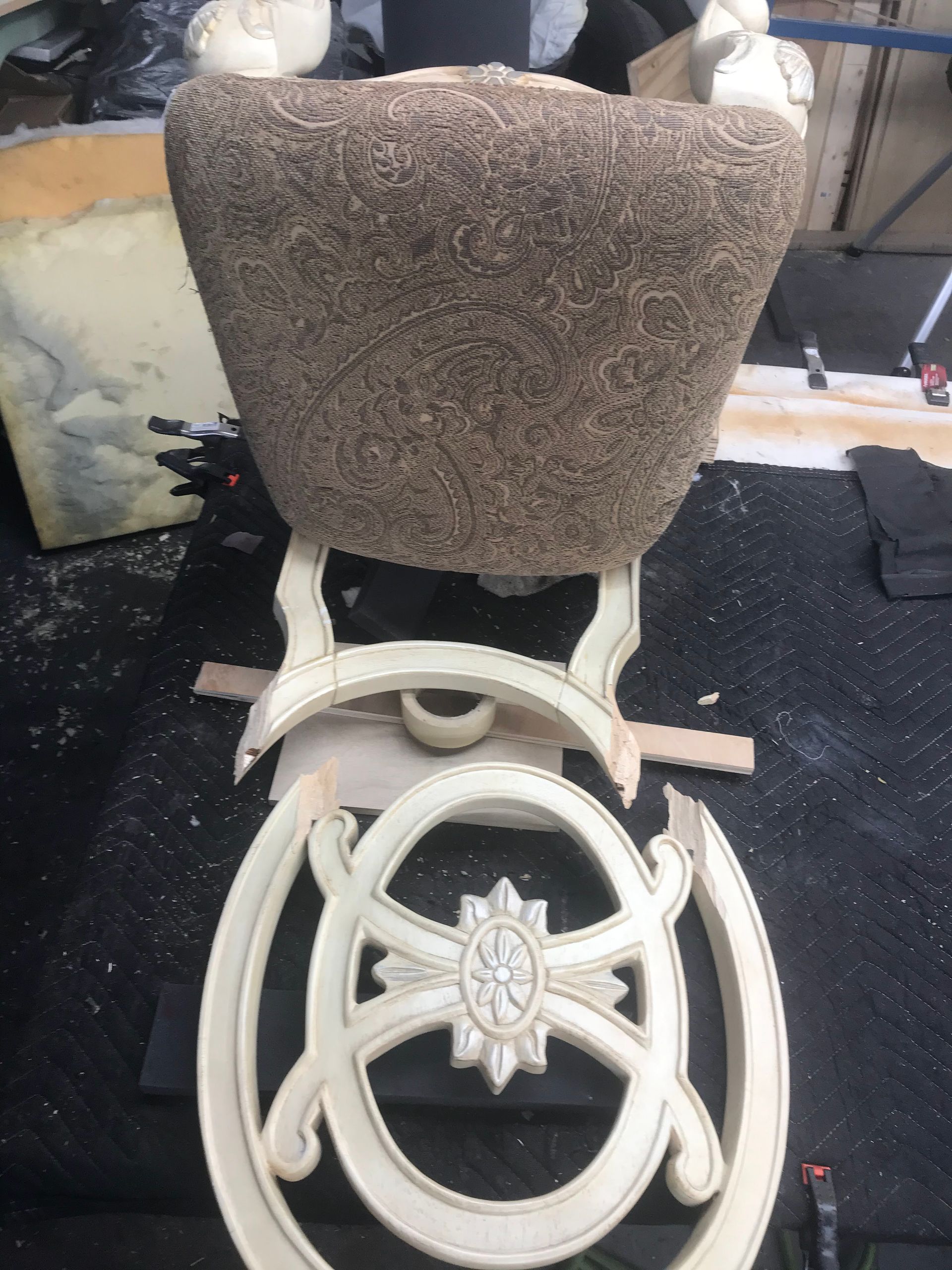 The back of a chair is being repaired in a workshop.