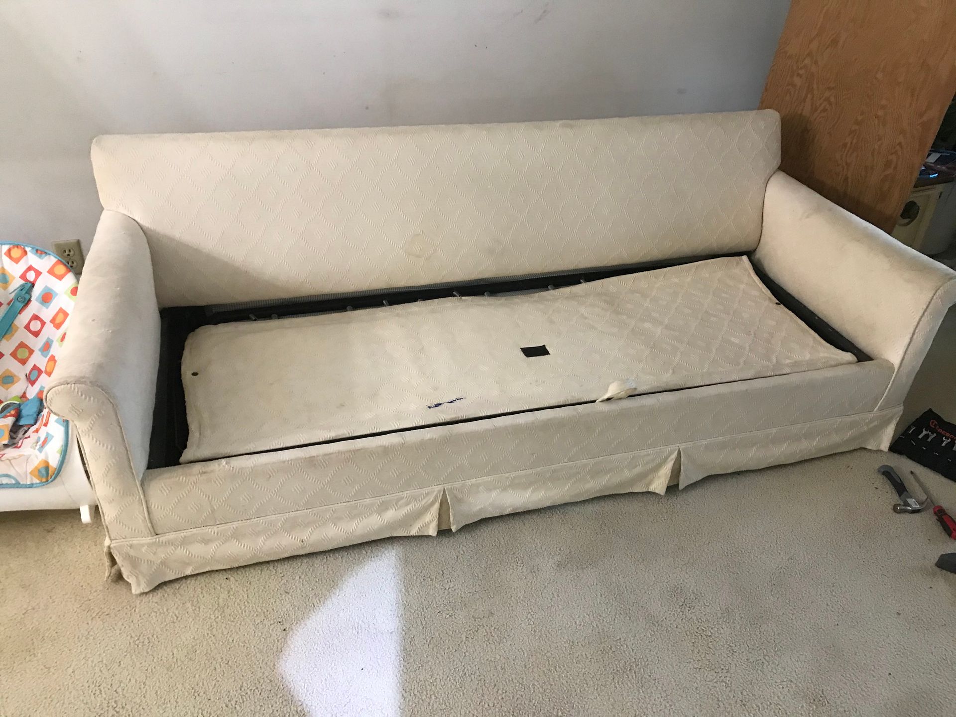 A white couch is sitting on a carpet in a room.