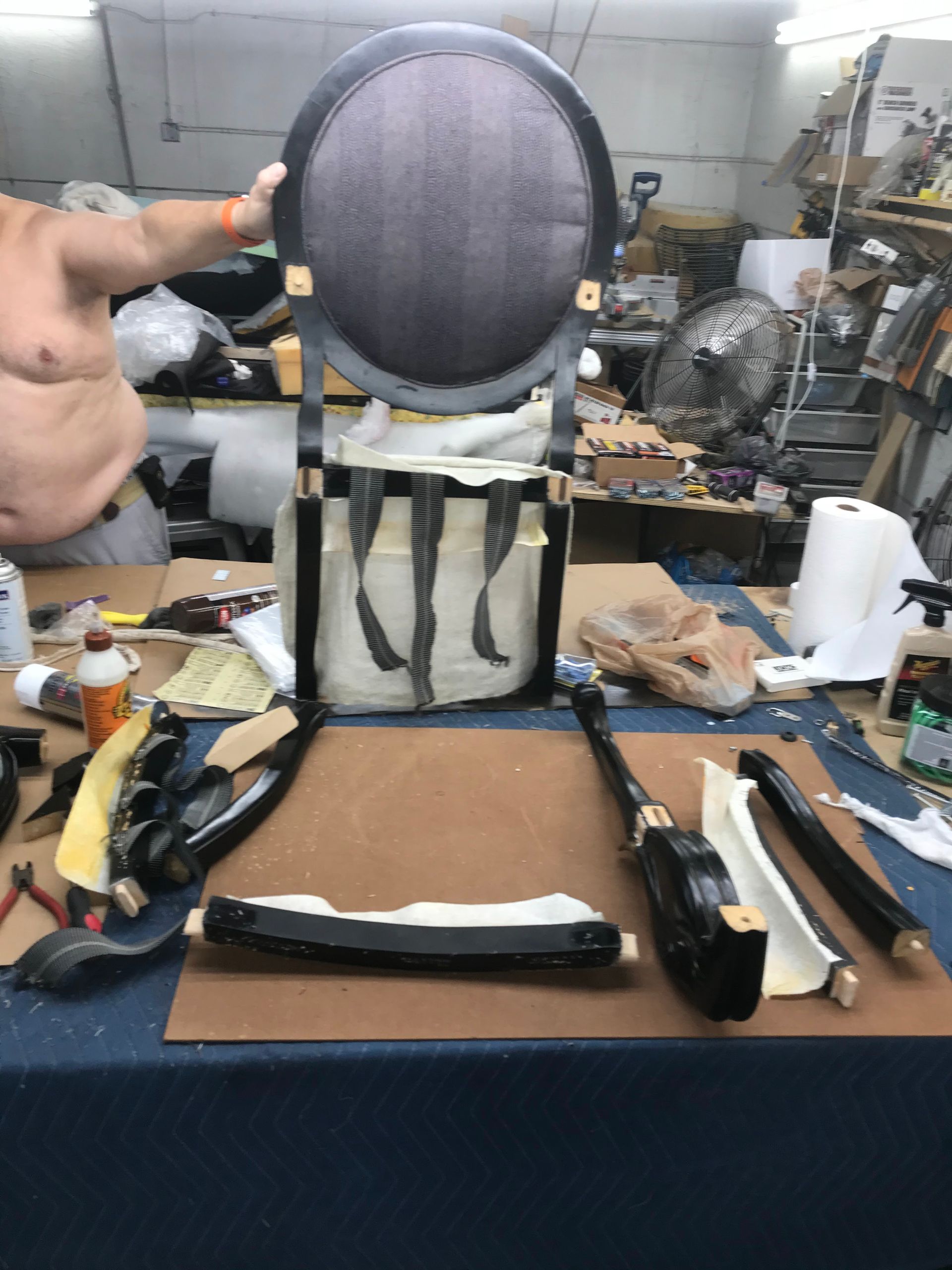 A man is working on a chair in a workshop
