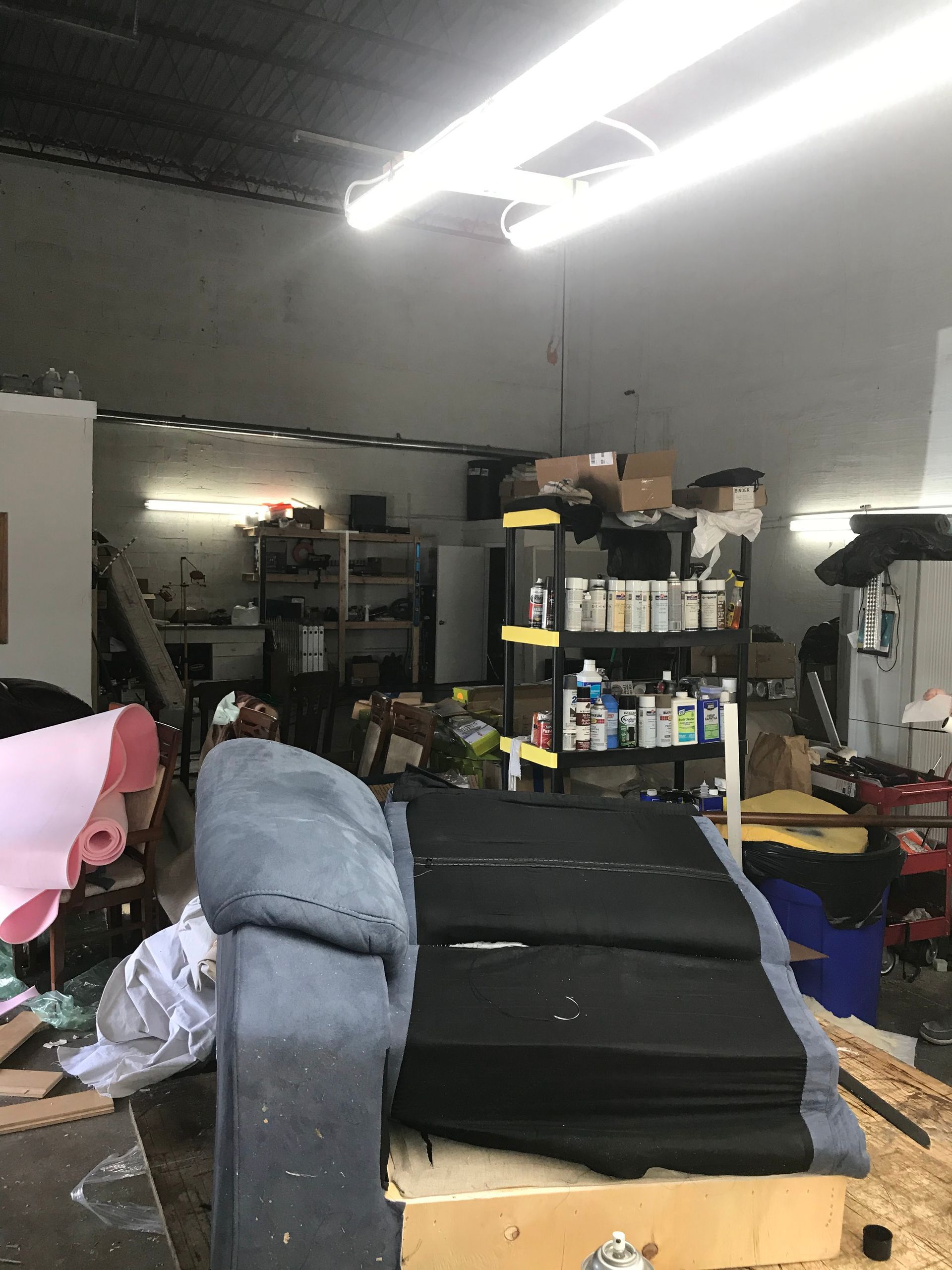 A couch is sitting on top of a wooden box in a messy room.