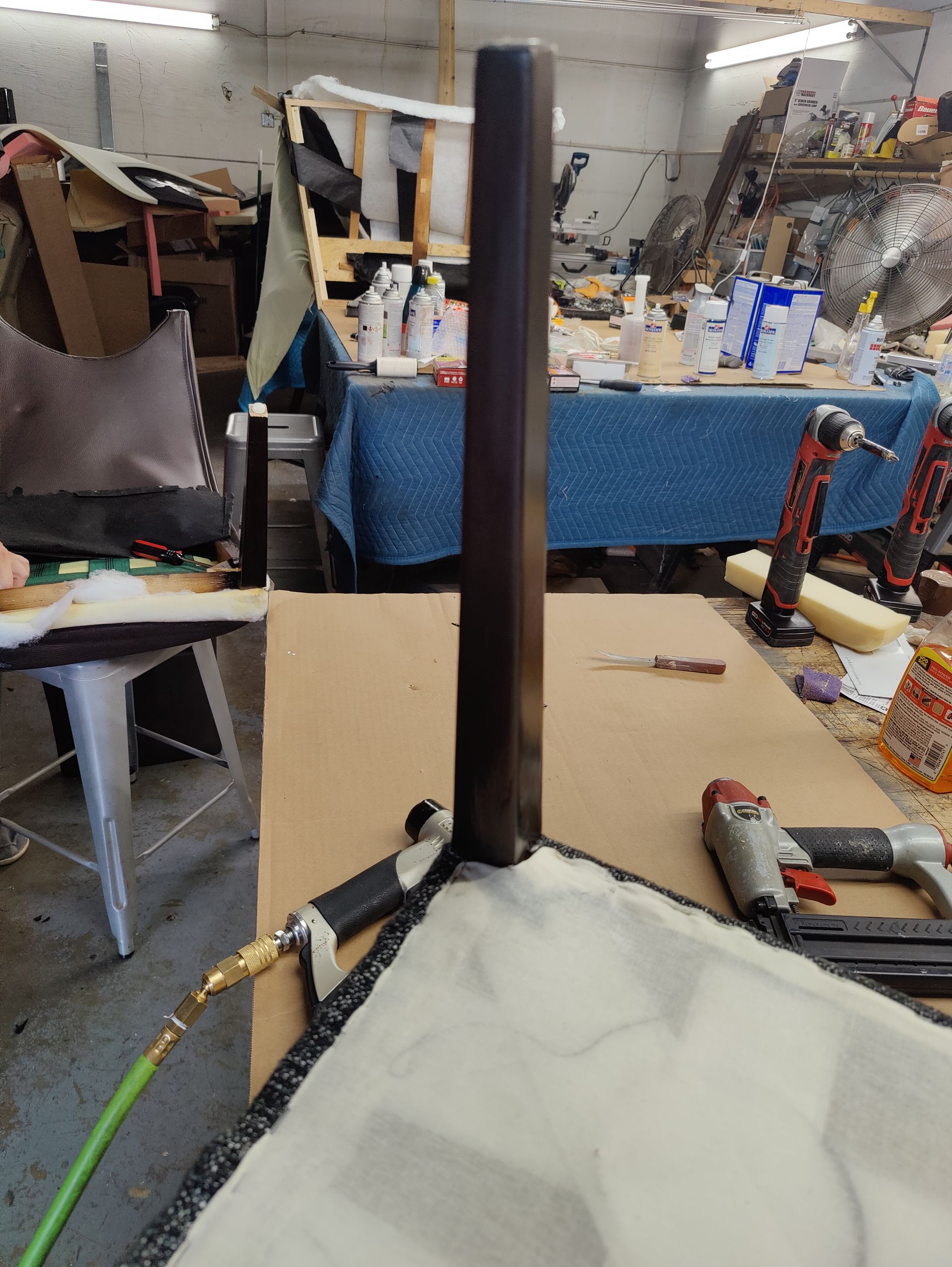 A person is working on a piece of furniture in a workshop.