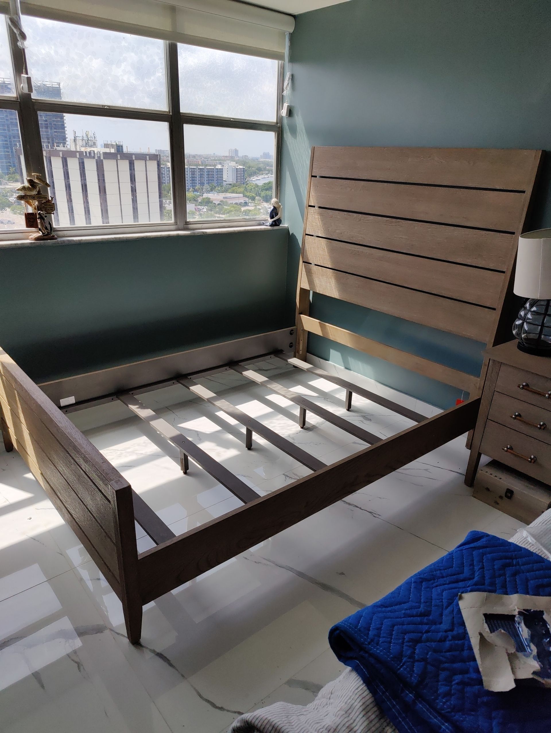 A bedroom with a wooden bed frame and a window
