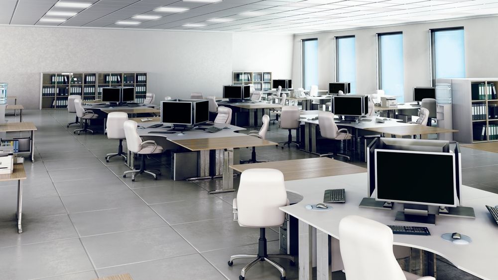 A large office with lots of desks and chairs and computers