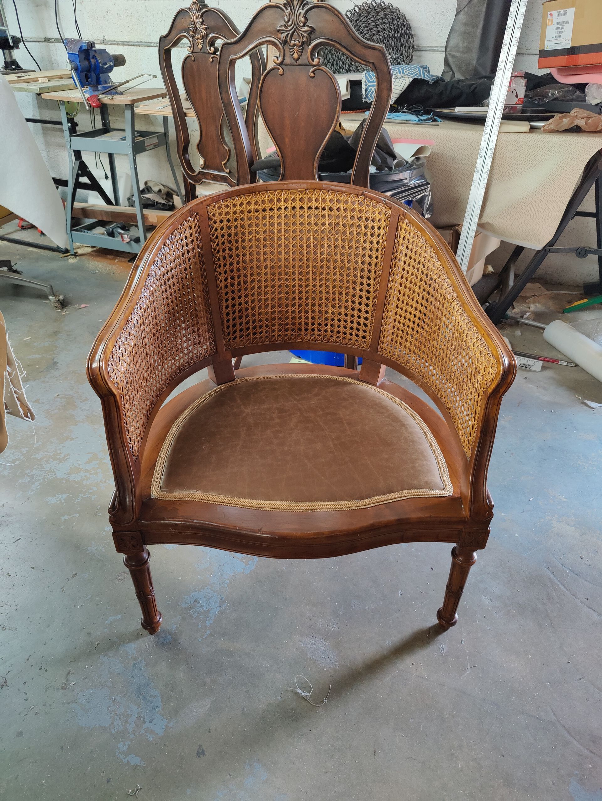 A chair with a wicker seat and back is sitting in a room.