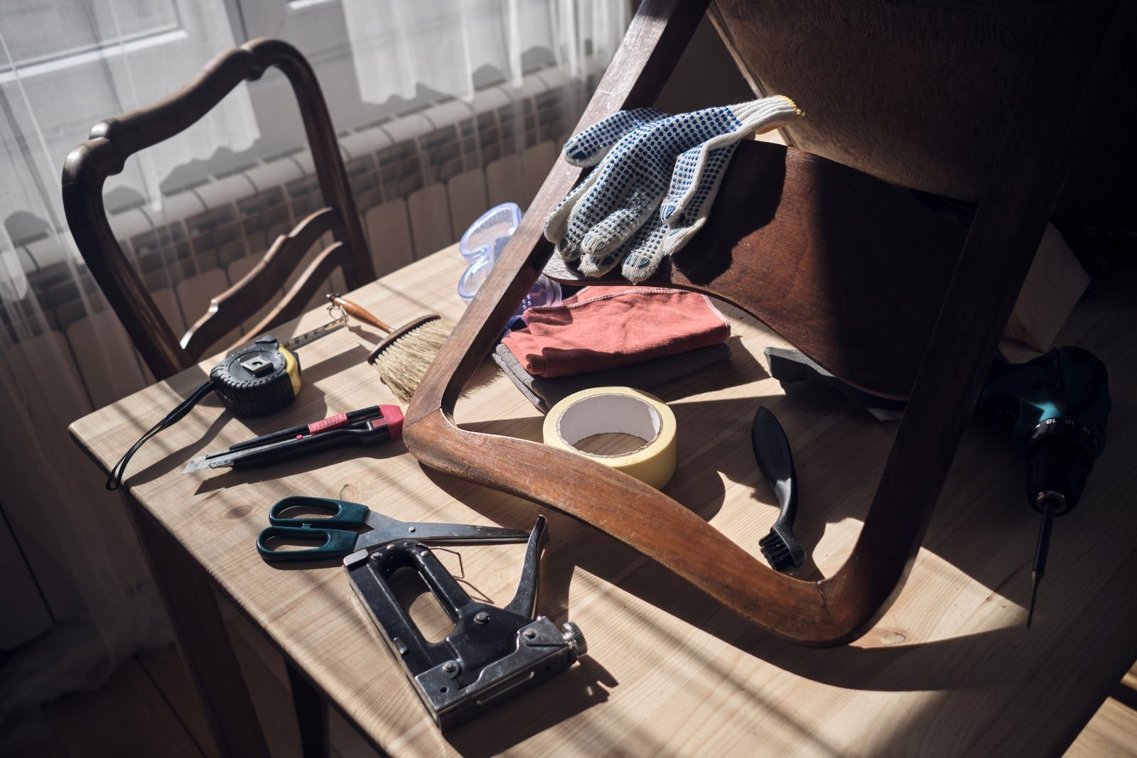 A wooden table with tools and a chair on it