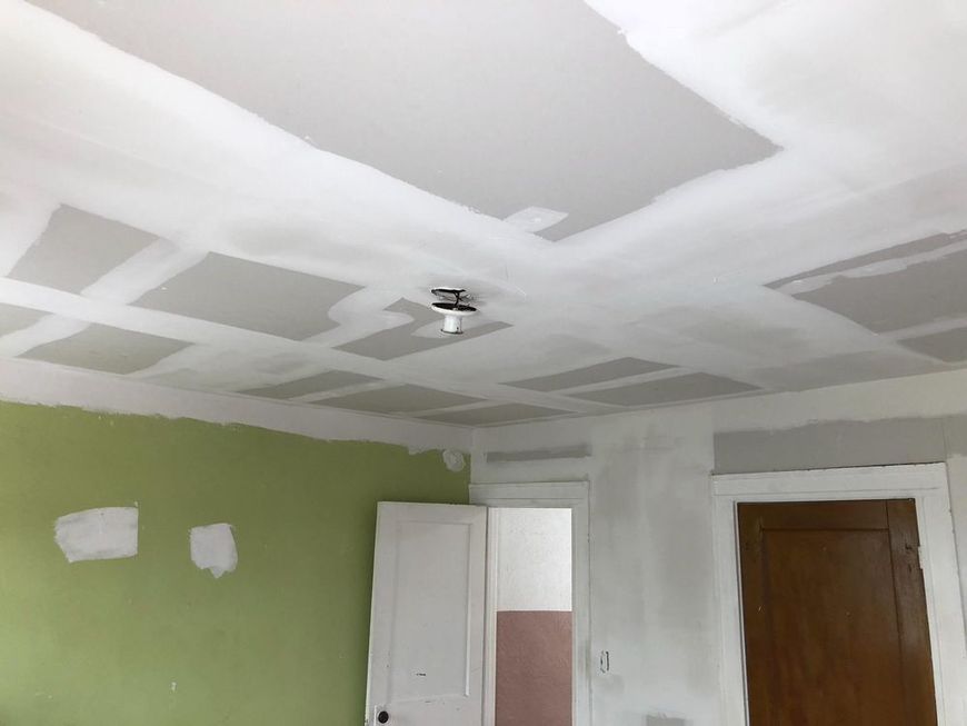 A room with a ceiling that is being painted white.