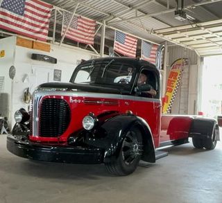 A red and black truck is parked in a garage