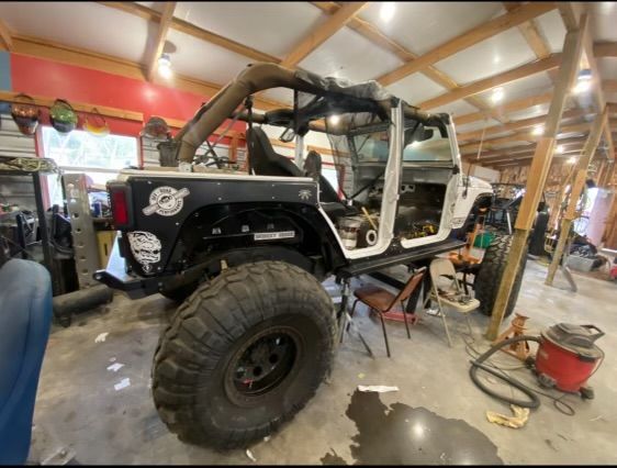 A jeep is being worked on in a garage