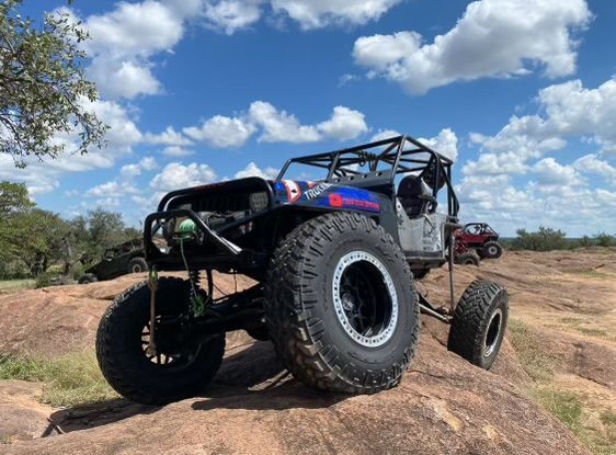 A jeep is parked on top of a rocky hill.