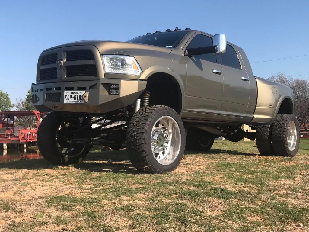 A dodge ram truck is parked in a grassy field.