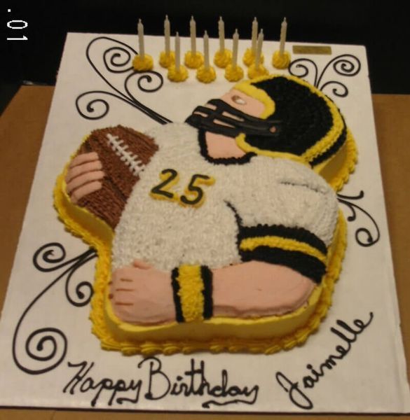 Football-themed birthday cake in the shape of a player in a white uniform, holding a ball. 