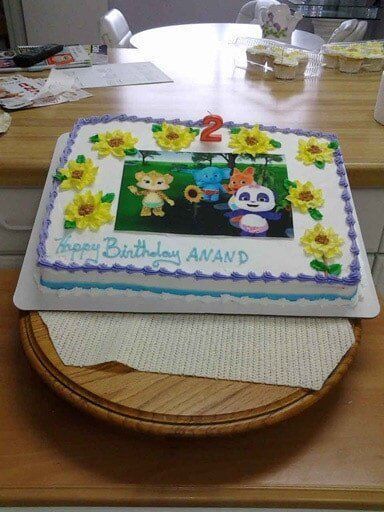 Birthday cake decorated with cartoon characters, sunflowers, and the number 