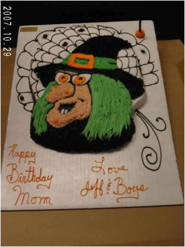 A Halloween-themed birthday cake featuring a witch with green hair and a black hat. The cake says 