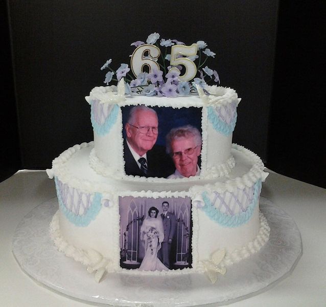 Two-tiered anniversary cake with photos of a couple, 