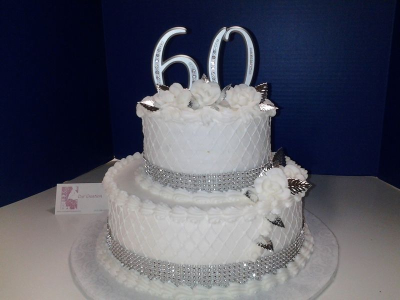 Two-tiered white birthday cake with silver trim and 
